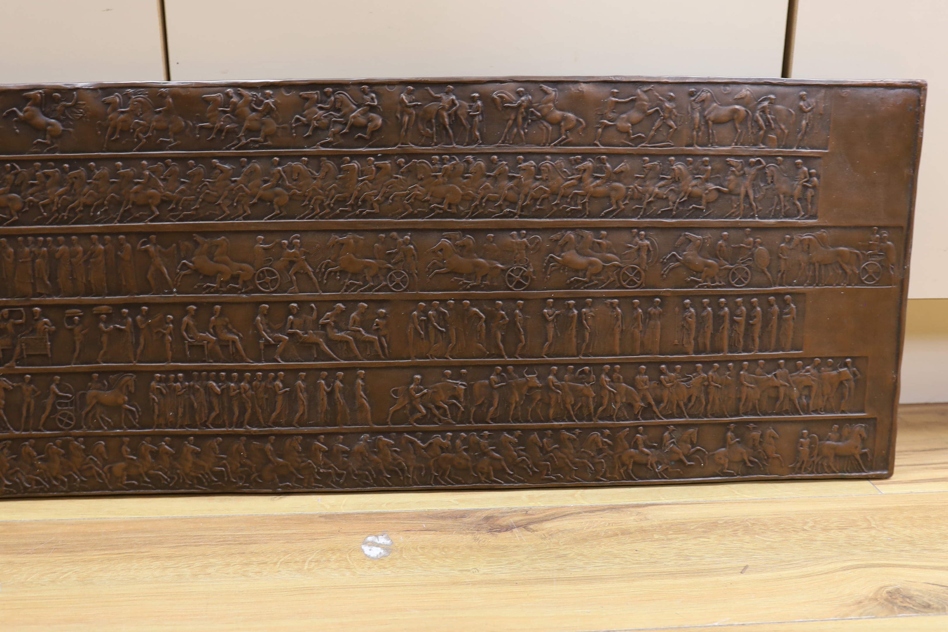 A copper effect resin plaque, 34 x 131cm